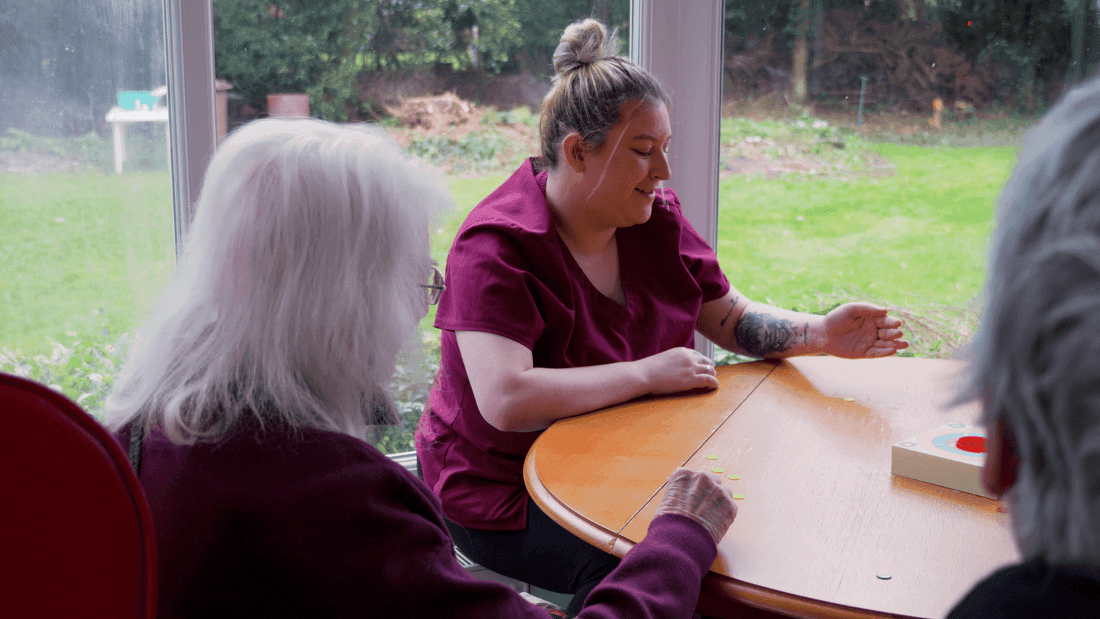 A carer playing a game with residents at Canwick House