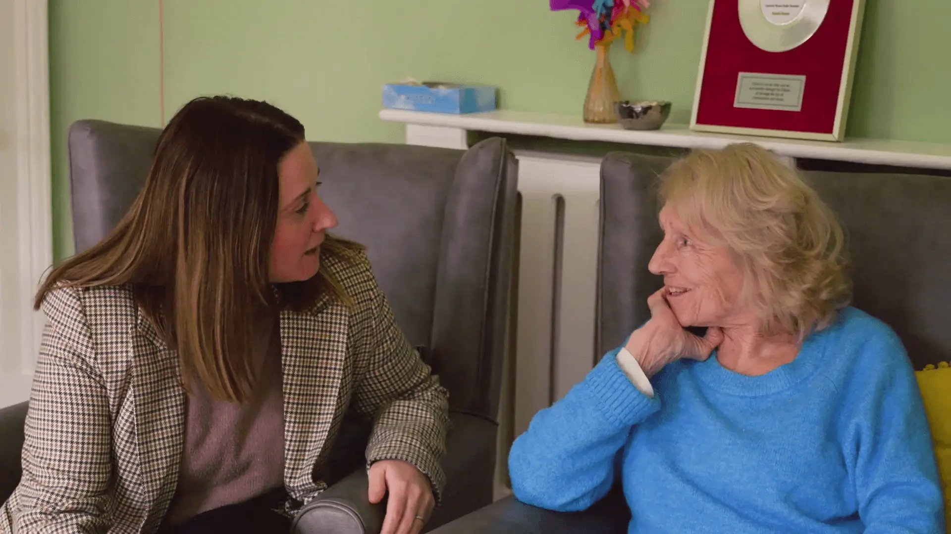 A visitor chatting warmly with a resident in the lounge